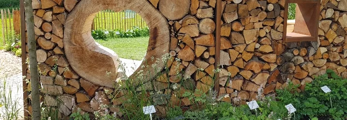 Holzstapel als Sichtschutz mit Gucklöchern